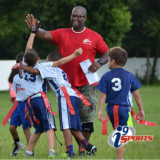 Coach gives high fives to his flag football players after scoring a touchdown.