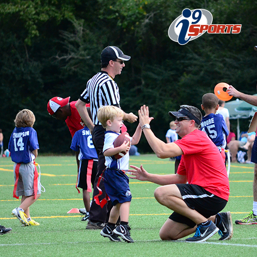 i9 Sports coach gives high five to a young flag football player