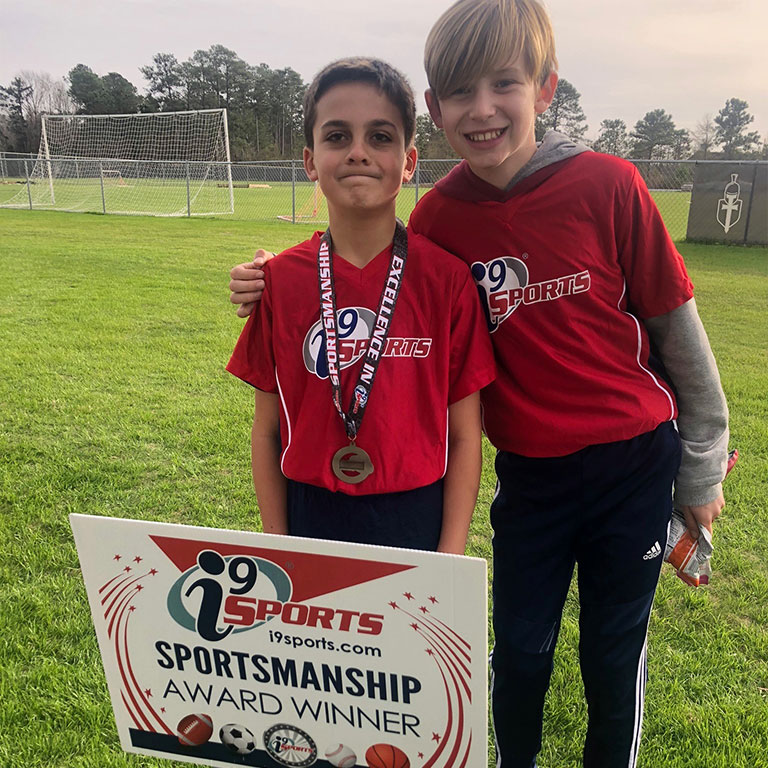 I9 Sports Wilmington NC sportsmanship winner poses with a friend after winning the weekly award for his team