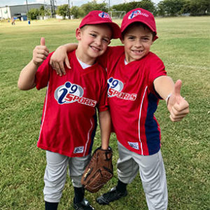 Two baseball players give a thumbs up after a fun game