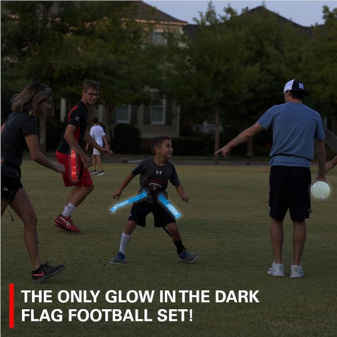 A young boy in all black cloths wearing bright blue glow-in-the-dark flag football flags around his waist.