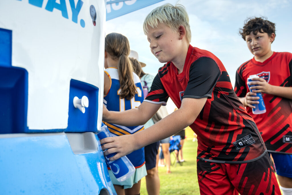 Young boy hydrating after his soccer game with his Cirkul water bottle.