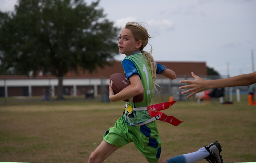 Young girl playing flag football.